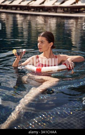 La giovane donna in costume da bagno rosso è in piscina. Foto Stock