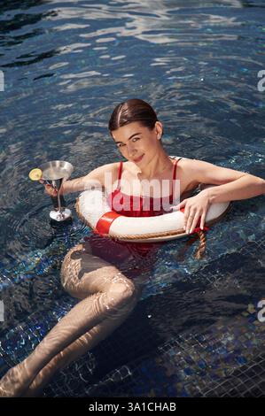 La giovane donna in costume da bagno rosso è in piscina. Foto Stock