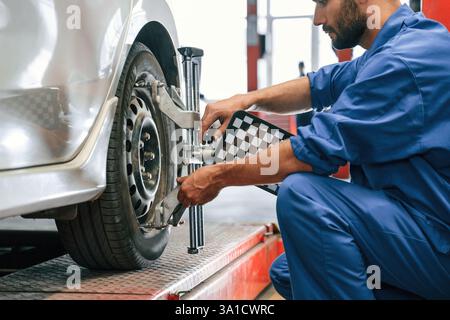 Attenzione al disco ruota. Meccanico che lavora in garage. Servizio di riparazione. Foto Stock