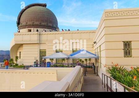Los Angeles, California - 14 dicembre 2024: Vista dell'iconica cupola dell'Osservatorio Griffith con i visitatori sul tetto e fiori colorati nel for Foto Stock