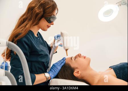 Ottenere la procedura di ringiovanimento fotografico presso la clinica di cosmetologia. Una donna sta ricevendo un massaggio hardware GPL nel salone di bellezza. Foto Stock