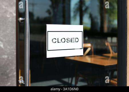 Cartello di chiusura sullo sportello di vetro di fronte al punto vendita Foto Stock