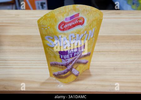 Una borsa di snack Campofrio n' FUEL pav è seduta su un tavolo di legno. Il sacchetto è giallo e ha un'etichetta bianca Foto Stock