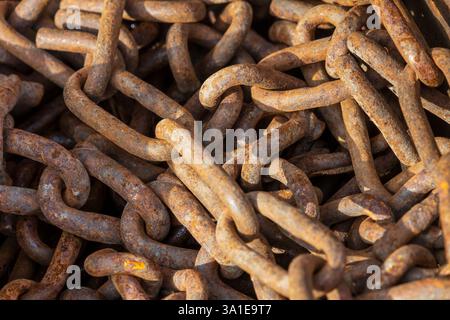 Un mucchio di catene arrugginite che mostrano i segni del tempo sul metallo Foto Stock
