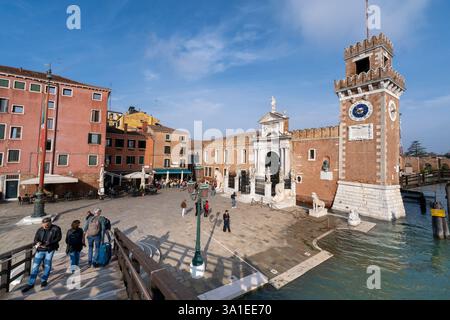 Venezia, Italia - 12 ottobre 2024: L'ingresso storico dell'Arsenale di Venezia con la sua porta in marmo ornato, la torre dell'orologio e il ponte in legno Foto Stock