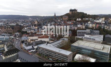 Una vista ad alto angolo di Marburgo, in Germania, che mostra il castello su una collina, la chiesa di Sant'Elisabetta, le case in legno e gli edifici moderni. Foto Stock