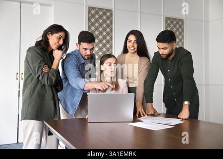 Gruppo di cinque professionisti che collaborano al progetto online in ufficio Foto Stock