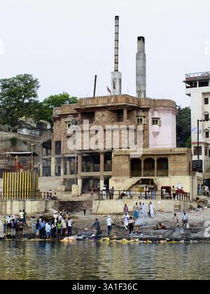 Cremazioni in corso a Harishchandra Ghat, uno dei più antichi ghat funzionanti lungo il fiume Gange a Varanasi, in India. Foto Stock