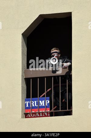 Ginevra, Illinois, Stati Uniti. 8 marzo 2025. 8 marzo 2025 Ginevra, Illinois, Stati Uniti: MATT BELDING, sostenitore dell'amministrazione solitaria di Trump, di St. Charles, Illinois, usa un megafono per esprimere il suo messaggio mentre i manifestanti del National Women's Day Rally costeggiano il ponte del fiume Fox a Ginevra, Illinois. (Credit Image: © H. Rick Bamman/ZUMA Press Wire) SOLO PER USO EDITORIALE! Non per USO commerciale! Foto Stock