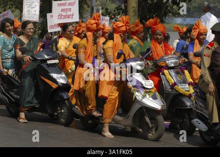 Processione di donne che indossano abiti tradizionali che cavalcano su due ruote per celebrare il festival Gudi Padva, il nuovo anno della religione indù, Thane, Maharasht Foto Stock