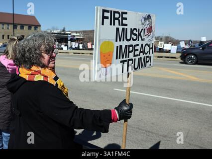Ginevra, Illinois, Stati Uniti. 8 marzo 2025. La protesta JENNIFER CALHOUN di Ginevra, Illinois, ha un segno che recita "Fire Musk, Impeach Trump" durante un raduno nazionale per la festa della donna. (Credit Image: © H. Rick Bamman/ZUMA Press Wire) SOLO PER USO EDITORIALE! Non per USO commerciale! Foto Stock