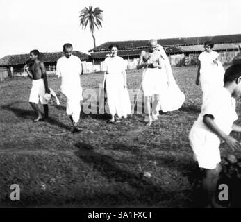 Mahatma Gandhi che cammina con Hanna Lazar (nipote del Dr. Hermann Kallenbach), Shardabehn e altri a Sevagram Ashram, 1938 NO MR Foto Stock