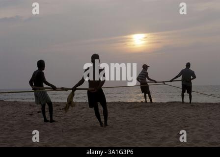 Attività di pesca, pescatori che sfruttano la rete per pescare al tramonto, mare arabo, spiaggia di Kunkeshwar, costa di Konkan, distretto di Sindhudurg, Maharashtra, India, Foto Stock
