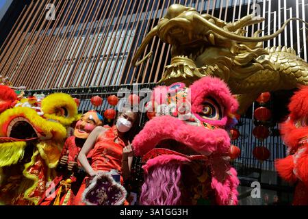 Bangkok, Tailandia - 21 gennaio 2023: Ballerini che si esibiscono nella danza del leone per una foto con una donna che celebra il Capodanno lunare cinese. Foto Stock