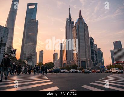 Shanghai, Cina - 17 marzo 2020: Incrocio affollato a Shanghai al tramonto con moderni grattacieli e pedoni che attraversano Foto Stock