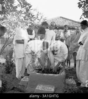 Mahatma Gandhi e Abha Gandhi piantano un albero tulsi a Sevagram Ashram, agosto 1944, dietro Abha Gandhi Pyarelal Nayar, portando sua nipote Nandini, P Foto Stock