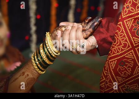 Sposo tenendo la mano di sposa eseguire vidhi rituale in maharashtrian cerimonia di nozze Foto Stock