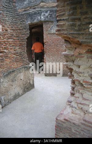 Uomo che entra nel cancello delle stanze di residenza in rovina, Lucknow, Uttar Pradesh, India, Asia Foto Stock