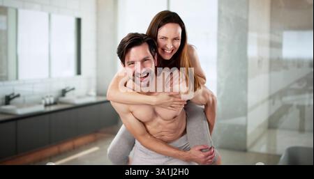 Una coppia sorridente in bagno si gode una divertente mattinata insieme a casa. professioni: idraulico, interior designer. Foto Stock