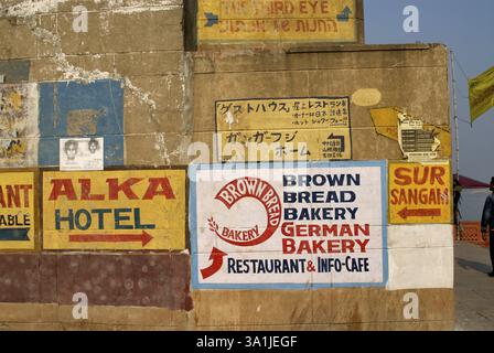 Indicazioni per ristoranti e hotel dipinti in inglese e cinese sulle pareti, Varanasi, Uttar Pradesh, India, Asia Foto Stock