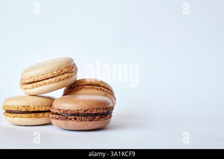 Quattro macaron francesi marroni, torte dai sapori diversi, caffè e creme brulee. Piramide di dessert fatti in casa, macaroon con vista laterale, spazio copie Foto Stock