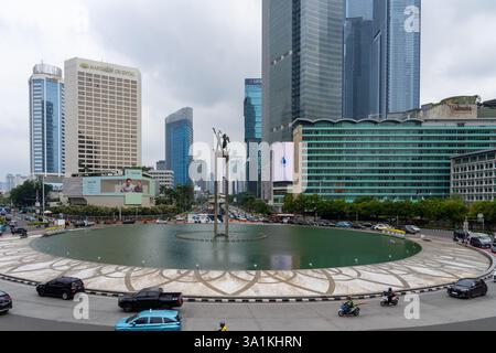 Giacarta, Indonesia - 23 gennaio 2025: Bundaran HI (Selamat Datang Monument) con grattacieli della città a Giacarta, Indonesia. Foto Stock