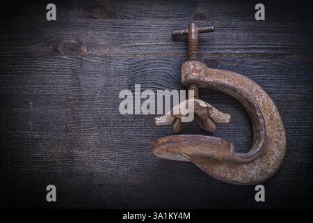 Vecchio morsetto su una tavola di legno vintage Foto Stock