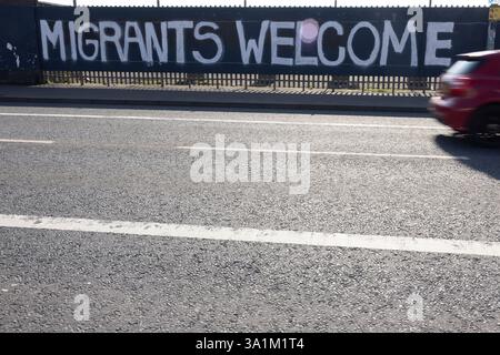 Belfast, Regno Unito. 9 marzo 2025. 09/03/2025 Belfast politica: Migranti benvenuto dipinto su accumulazione a West Belfast credito: Bonzo/Alamy Live News Foto Stock
