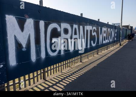 Belfast, Regno Unito. 9 marzo 2025. 09/03/2025 Belfast politica: Migranti benvenuto dipinto su accumulazione a West Belfast credito: Bonzo/Alamy Live News Foto Stock