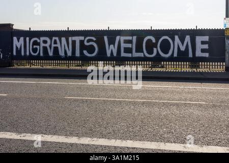 Belfast, Regno Unito. 9 marzo 2025. 09/03/2025 Belfast politica: Migranti benvenuto dipinto su accumulazione a West Belfast credito: Bonzo/Alamy Live News Foto Stock