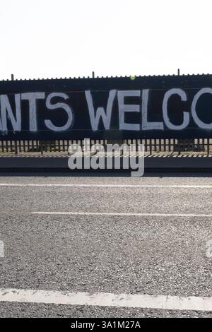 Belfast, Regno Unito. 9 marzo 2025. 09/03/2025 Belfast politica: Migranti benvenuto dipinto su accumulazione a West Belfast credito: Bonzo/Alamy Live News Foto Stock