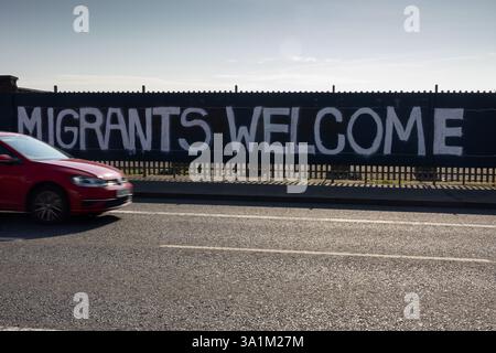 Belfast, Regno Unito. 9 marzo 2025. 09/03/2025 Belfast politica: Migranti benvenuto dipinto su accumulazione a West Belfast credito: Bonzo/Alamy Live News Foto Stock