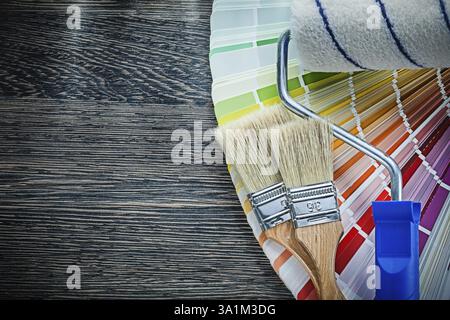 Pennelli a rullo ventola pantone colorata su tavola di legno Foto Stock
