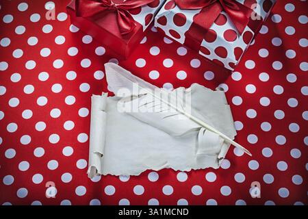 Presenta un foglio di carta vintage in piuma su tessuto rosso a pois per festeggiare Foto Stock