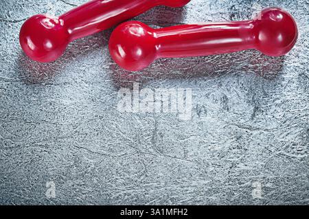 Un paio di manubri rossi su sfondo argento Foto Stock