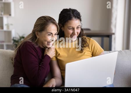 Due generazioni diverse di donne che usano un notebook a casa Foto Stock