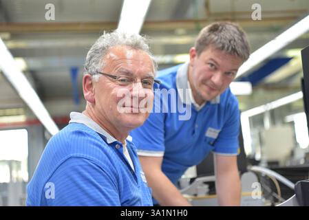 Ingegnere di lavoro su una macchina per il montaggio e la produzione di schede a semiconduttore in un impianto industriale Foto Stock