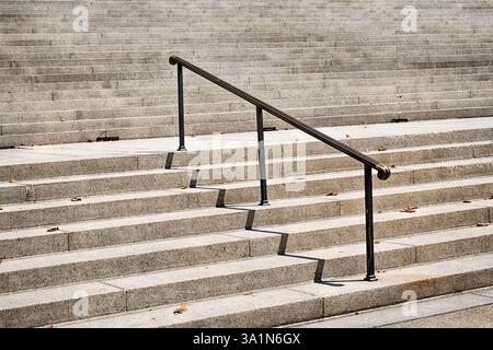 Un unico corrimano metallico sale su una parte dei molti gradini che portano all'ingresso principale dell'edificio degli Archivi nazionali a Washingtion, DC. Foto Stock