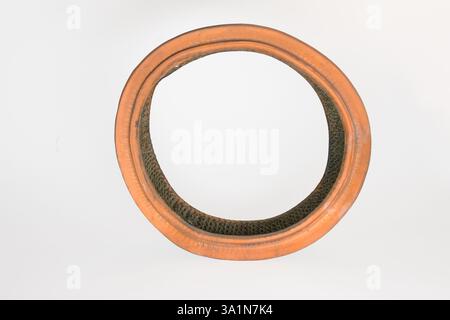 filtro dell'aria rotondo per auto, con carta intasata e rete metallica sulla superficie interna. vecchio, polveroso e usurato, isolato su sfondo bianco Foto Stock