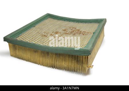 filtro dell'aria in carta con rete metallica dura sulla superficie inferiore. manutenzione. vecchio, arrugginito. pezzo di ricambio rettangolare del sistema di aspirazione dell'aria, con bordo morbido verde Foto Stock