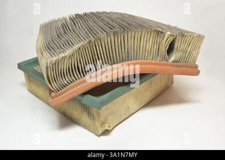 Filtro dell'aria del motore del sistema di aspirazione dell'aria per autoveicoli, pila di due filtri usati, polverosi con cerchioni di tenuta colorati e materiale filtrante di carta intasato Foto Stock