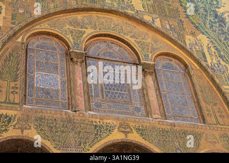 Elaborato design a mosaico caratterizzato da motivi vivaci e dettagli estetici in un edificio storico. Include squisite finestre ad arco adornate da intriganti Foto Stock