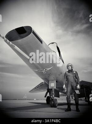 George Cooper, pilota collaudatore del National Advisory Committee for Aeronautics, o NACA, si trova accanto ad un F-100 nordamericano, un caccia supersonico testato dalla NACA. Foto Stock