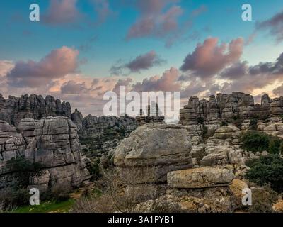 Rocce calcaree impilate l'una sull'altra in interessanti formazioni a El Torcal de Antequera Sapin, cielo al tramonto Foto Stock