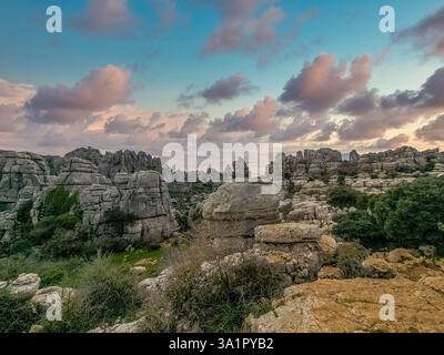 Rocce calcaree impilate l'una sull'altra in interessanti formazioni a El Torcal de Antequera Sapin, cielo al tramonto Foto Stock