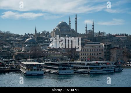 Vista panoramica dello skyline di Istanbul con le cupole e i minareti della Moschea Suleymaniye che si innalzano sopra la città storica con le barche turistiche attraccate nel Bosphorus Waterf Foto Stock