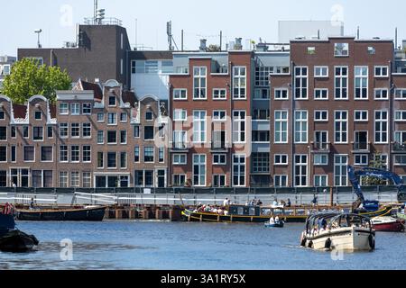 Facciate di edifici ad Amsterdam, storiche case in mattoni sul canale in fila. Foto Stock