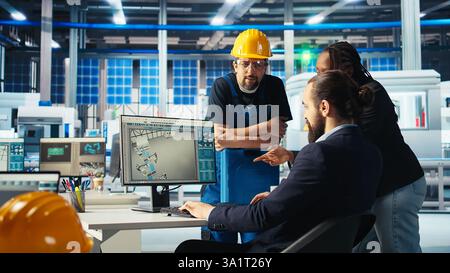 Il responsabile della fabbrica di fotovoltaico assegna compiti ai lavoratori, chiedendo loro di regolare i parametri del sistema. Team leader che spiega ai dipendenti come ottimizzare la fornitura di energia nell'impianto di produzione di pannelli solari, telecamera A. Foto Stock