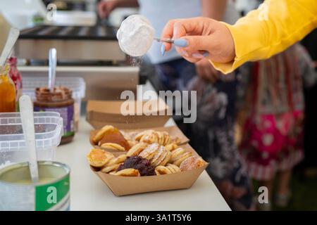 Mini Pancakes olandesi Poffertjes. Soffici mini frittelle che vengono servite con un po' di zucchero a velo e marmellata. Tipico poffertjes olandese - piccoli pancake. Foto Stock