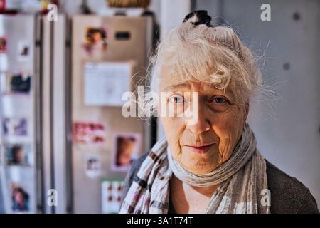 Ritratto di una donna anziana dai capelli grigi in cucina. Copia spazio. Foto Stock